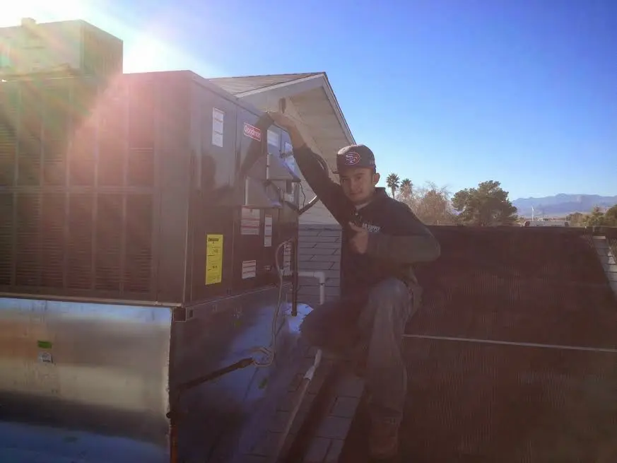HVAC technician performing Boiler Repair on a rooftop unit in Socorro